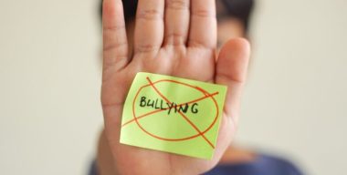 Child,Making,Stop,Gesture,With,Anti-bullying,Message,On,Sticky,Notes,