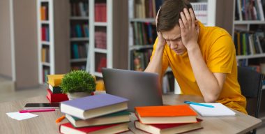 Exhausted,Caucasian,Student,Stucked,In,Front,Of,Laptop,,Touching,His